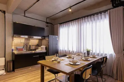 a dining room with a table and a kitchen at Townhouse at Sathu Pradit road in Bangkok