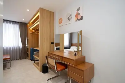 a hotel room with a desk and a bedroom at Townhouse at Sathu Pradit road in Bangkok