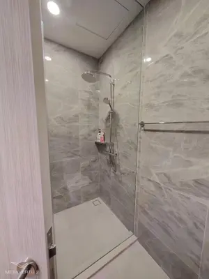 a shower with a glass door in a bathroom at Brand New 2 bedroom near Paragon in Pratunam