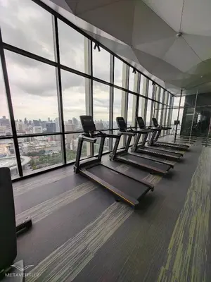 a row of treadmills in a gym with windows at Brand New 2 bedroom near Paragon in Pratunam