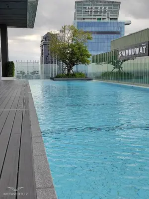 a large swimming pool with a tree in the middle at Brand New 2 bedroom near Paragon in Pratunam