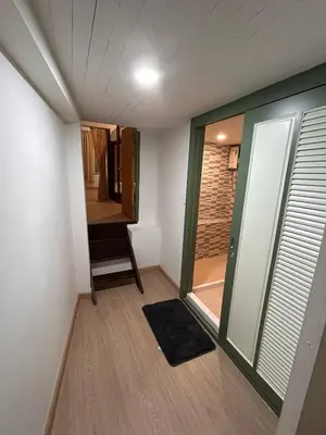 a room with a door and a chair in a room at Ni Haus, cozy place for 4 people in Bangkok