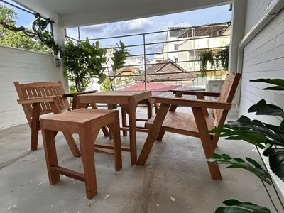a wooden table and two chairs on a patio at Ni Haus, cozy place for 4 people in Bangkok