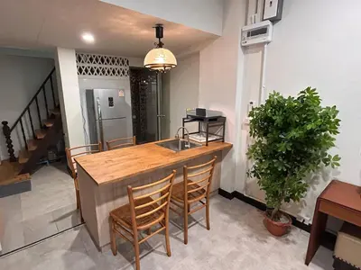 a kitchen with a counter with chairs and a sink at Ni Haus, cozy place for 4 people in Bangkok