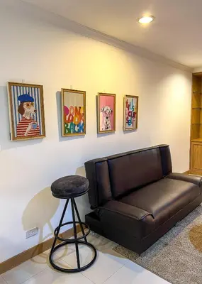 a living room with a leather couch and a stool at Panoramic River View Residence in Bangkok