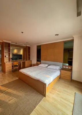 a bedroom with a large bed and a kitchen at Panoramic River View Residence in Bangkok