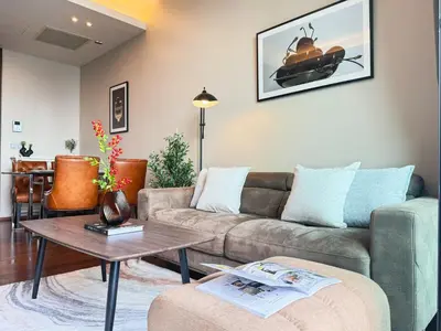 a living room with a couch and a table at Near BTS - High Floor - Pool and Gym - Sontana in Bangkok