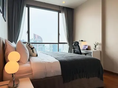 a bedroom with a bed and a large window at Near BTS - High Floor - Pool and Gym - Sontana in Bangkok