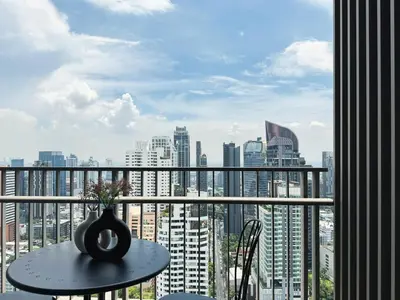 a table with a vase sitting on top of a balcony at Near BTS - High Floor - Pool and Gym - Sontana in Bangkok