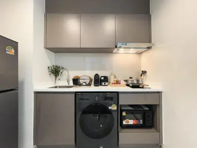 a kitchen with a dishwasher and a sink in it at Near BTS - High-Floor - Rooftop Pool - Sontana in Bangkok