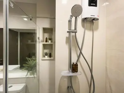a shower with a shower head in a bathroom at Near BTS - High-Floor - Rooftop Pool - Sontana in Bangkok