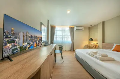 a hotel room with a large tv on the wall at Ralph Poshtel Sukhumvit in Bangkok