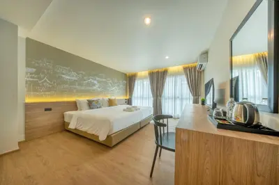 a hotel room with a bed and a desk with a desk at Ralph Poshtel Sukhumvit in Bangkok