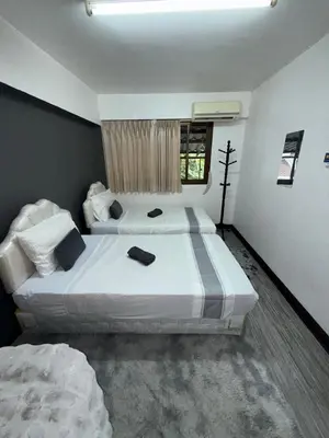a bedroom with two beds and a window at Ree House- Sukhumvit 23 in Bangkok
