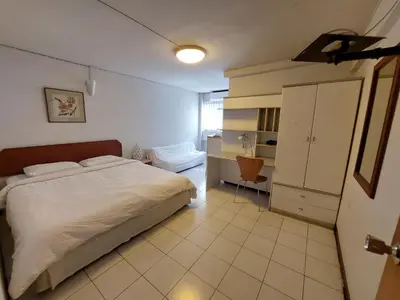 a bedroom with a white bed and a cabinet at BaanSathorn21 in Bangkok