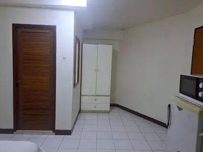 a room with a kitchen with a door and a microwave at BaanSathorn21 in Bangkok