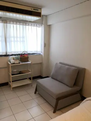 a living room with a couch and a window at BaanSathorn21 in Bangkok