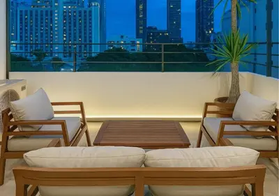 a room with two chairs and a table and a balcony at Solumie Boutique Hotel in Bangkok