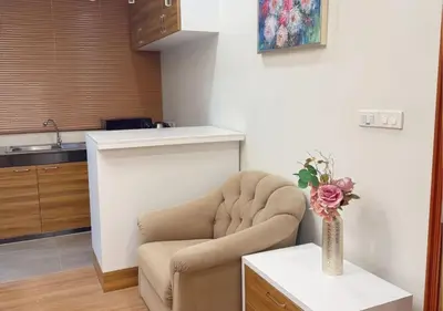 a living room with a chair and a vase with flowers at Solumie Boutique Hotel in Bangkok