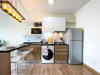 a kitchen with a refrigerator and a dishwasher at Prime Sukhumvit Living - BTS Phrom Phong - Ultra Fast WiFi in Bangkok