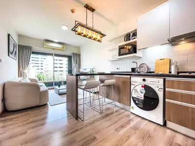 a kitchen and living room with a washer and dryer at Prime Sukhumvit Living - BTS Phrom Phong - Ultra Fast WiFi in Bangkok
