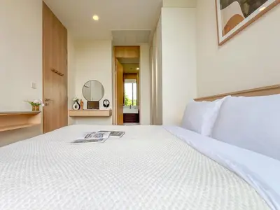 a bedroom with a white bed with a magazine on it at Asoke Luxury High Rise - Steps to BTS and MRT - WiFi in Bangkok