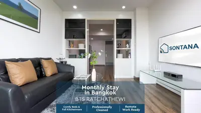 a living room with a couch and a tv at Downtown Stay 65 sqm - Ultra-WiFi - BTS Ratchathewi in Bangkok