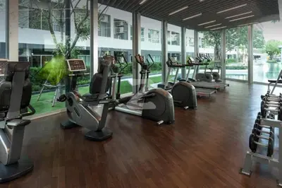 a gym with rows of treadmills and elliptical machines at Elio Sukhumvit 64 BTS Punnawithi in Amphoe Phra Khanong