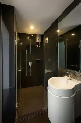 a bathroom with a sink and a glass shower at Stylish Sukhumvit 36 Condo Near BTS Thonglor in Bangkok