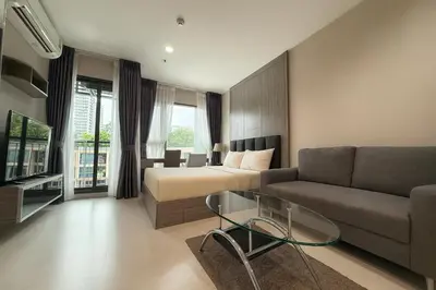 a living room with a bed and a couch at Stylish Sukhumvit 36 Condo Near BTS Thonglor in Bangkok