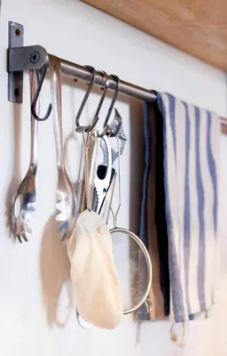 a rack of utensils hanging on a wall at HOLY SHEET Hostel in Bangkok