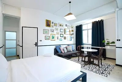 a white bedroom with a bed and a table and chairs at XX The Character Yaowarat-ตรอกข้าวสาร in Samphanthawong