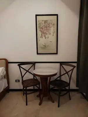 a table and two chairs and a picture on a wall at XX The Character Yaowarat-ตรอกข้าวสาร in Samphanthawong