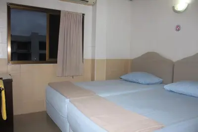 a bedroom with a white bed and a window at At Home Guest House in Bangkok