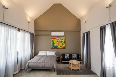 a bedroom with a bed and a chair at Crownex Studio Deluxe in Bangkok