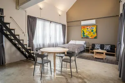 a bedroom with a bed and a table and chairs at Crownex Studio Deluxe in Bangkok