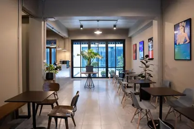 a restaurant with tables and chairs in a room at Crownex Studio Deluxe in Bangkok