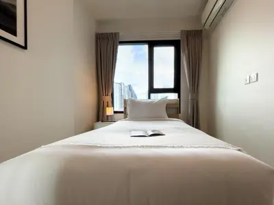 a bedroom with a large white bed with a window at 150 m to MRT l Workspace and Kitchen l Suana l Sontana in Bangkok