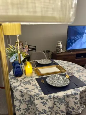 a table with two plates and a candle on it at Omni Tower Sukhumvit Nana - Luxury Condominium in Bangkok