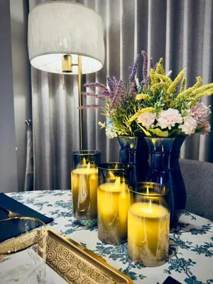 a table with candles and a vase with flowers at Omni Tower Sukhumvit Nana - Luxury Condominium in Bangkok