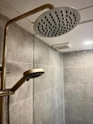 a shower with a shower head in a bathroom at Omni Tower Sukhumvit Nana - Luxury Condominium in Bangkok