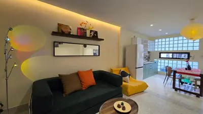 a living room with a green couch and a kitchen at TownHouse near Central Ladprao with bathtub in Bangkok