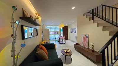 a living room with a couch and a staircase at TownHouse near Central Ladprao with bathtub in Bangkok