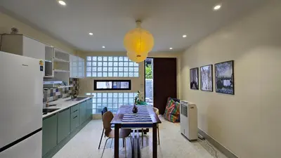 a kitchen with a table and a light fixture at TownHouse near Central Ladprao with bathtub in Bangkok