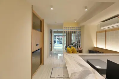 a kitchen with a counter and a living room at Tori primo hotel in Bangkok