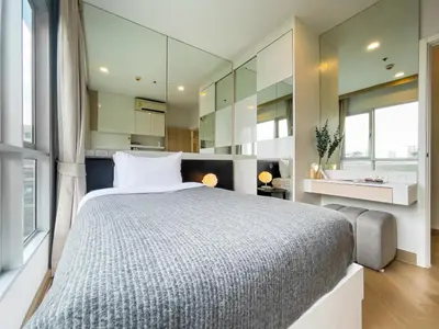 a bedroom with a large bed and a bathroom at Elegant Stay near IconSiam l High-speed WiFi l BTS Wongwian Yai in Bangkok