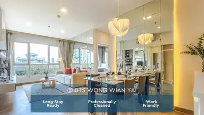 a living room with a dining table and a couch at Elegant Stay near IconSiam l High-speed WiFi l BTS Wongwian Yai in Bangkok