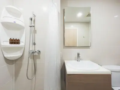 a white bathroom with a sink and a shower at Elegant Stay near IconSiam l High-speed WiFi l BTS Wongwian Yai in Bangkok