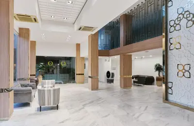 a lobby with couches and chairs in a building at The Platinum Suites Bangkok by Dancenter in Bangkok