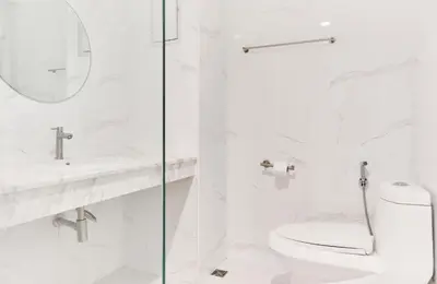 a white bathroom with a toilet and a sink at The Platinum Suites Bangkok by Dancenter in Bangkok
